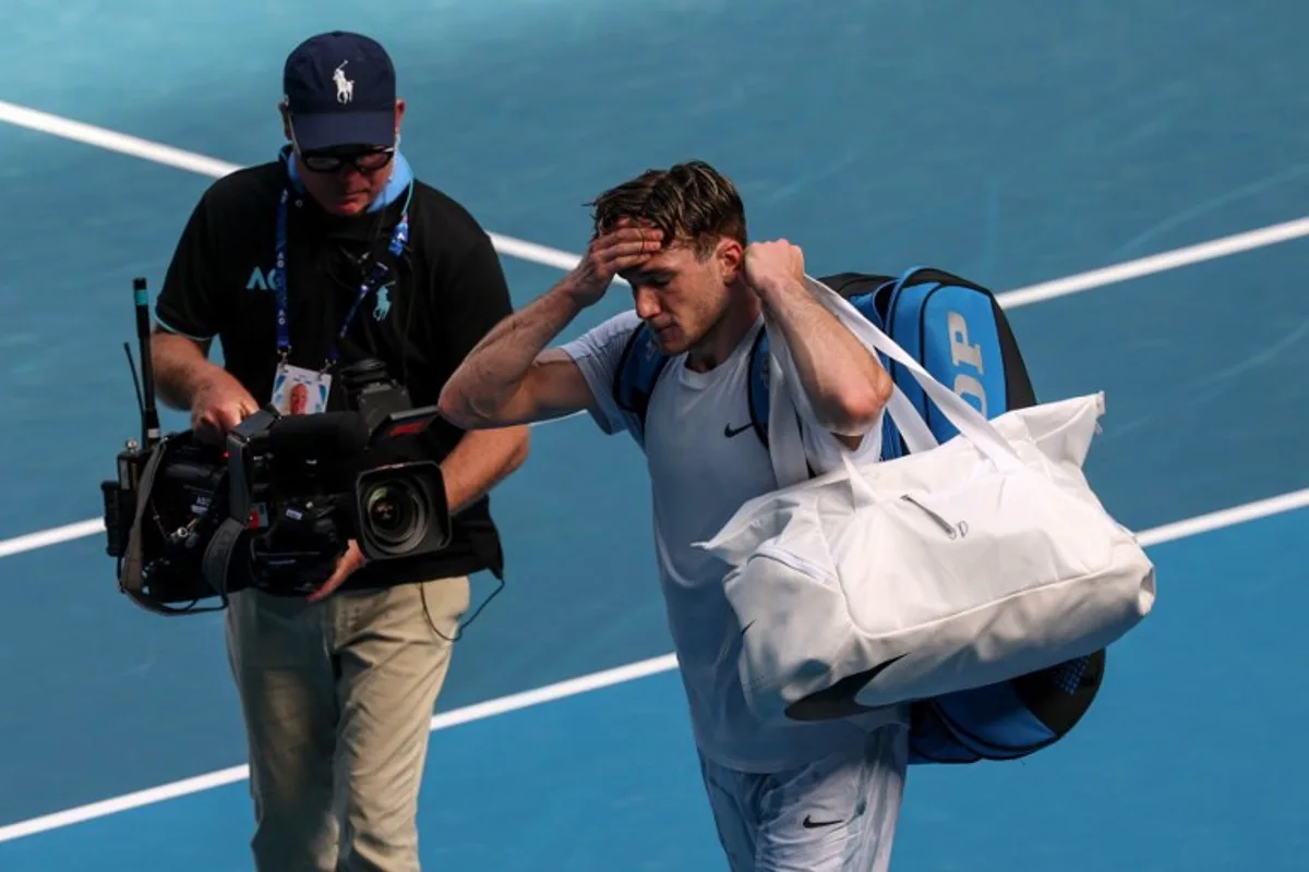 Britain's Jack Draper gestures as he retires from his men's singles match against Spain's Carlos Alcaraz on day eight of the Australian Open tennis tournament in Melbourne on January 19, 2025.  DAVID GRAY / AFP