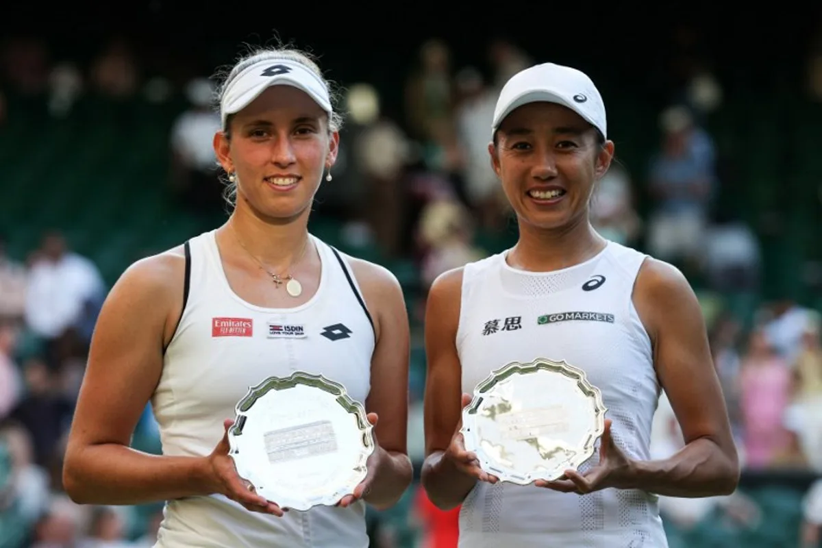 Runners-up Belgium's Elise Mertens (L) and China's Zhang Shuai pose with their trophies after being defeated during their women's doubles final tennis match against Czech Republic's Barbora Krejcikova and Katerina Siniakova on the fourteenth day of the 2022 Wimbledon Championships at The All England Tennis Club in Wimbledon, southwest London, on July 10, 2022.   Adrian DENNIS / AFP