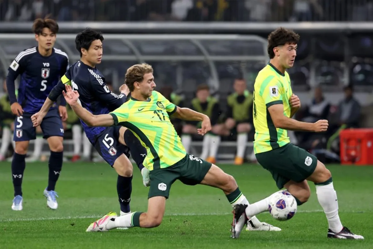 Australia's Ryan Teague (C) attempts to gain possession of the ball during the 2026 FIFA World Cup Asian Qualifier match between Australia and Japan at Optus Stadium in Perth on June 5, 2025. COLIN MURTY / AFP