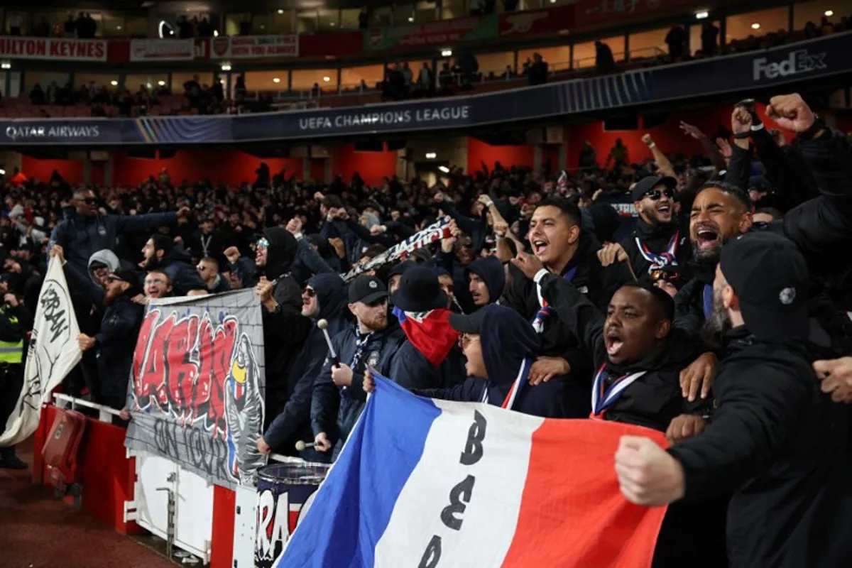 PSG fans cheer ahead of the UEFA Champions League football match between Arsenal and Paris Saint-Germain (PSG) at the Emirates Stadium in north London on October 1, 2024.  Adrian Dennis / AFP