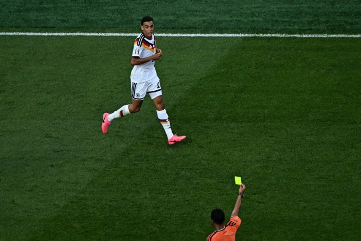 Moroccan referee Jalal Jayed shows a yellow card to Germany's midfielder #10 Jamal Musiala during the 2026 World Cup round of 32 football match between Germany and Paraguay at the Boston Stadium in Foxborough on June 29, 2026. Jewel SAMAD / AFP