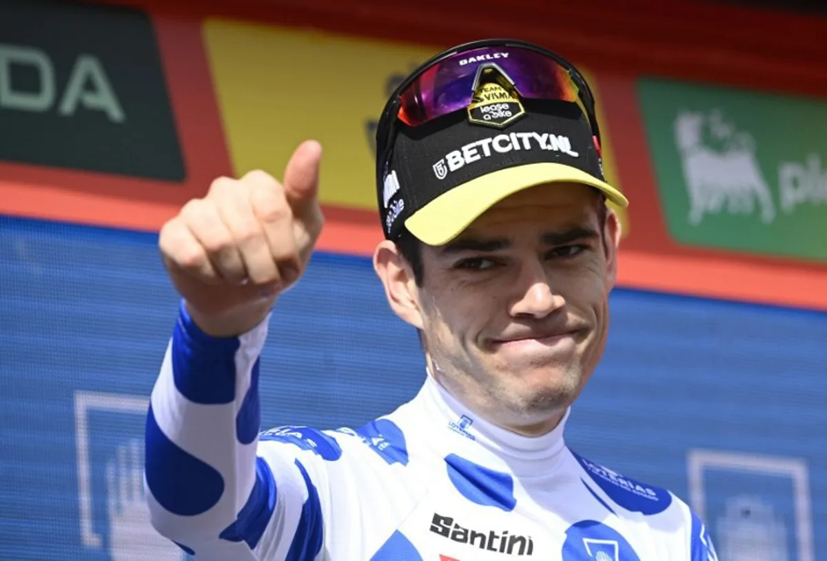 Climber ranking leader Team Visma's Wout van Aert wearing his dotted jersey celebrates on the podium after the stage 14 of the Vuelta a Espana, a 200,5 km race between Villafranca del Bierzo and Villablino, on August 31, 2024.    MIGUEL RIOPA / AFP