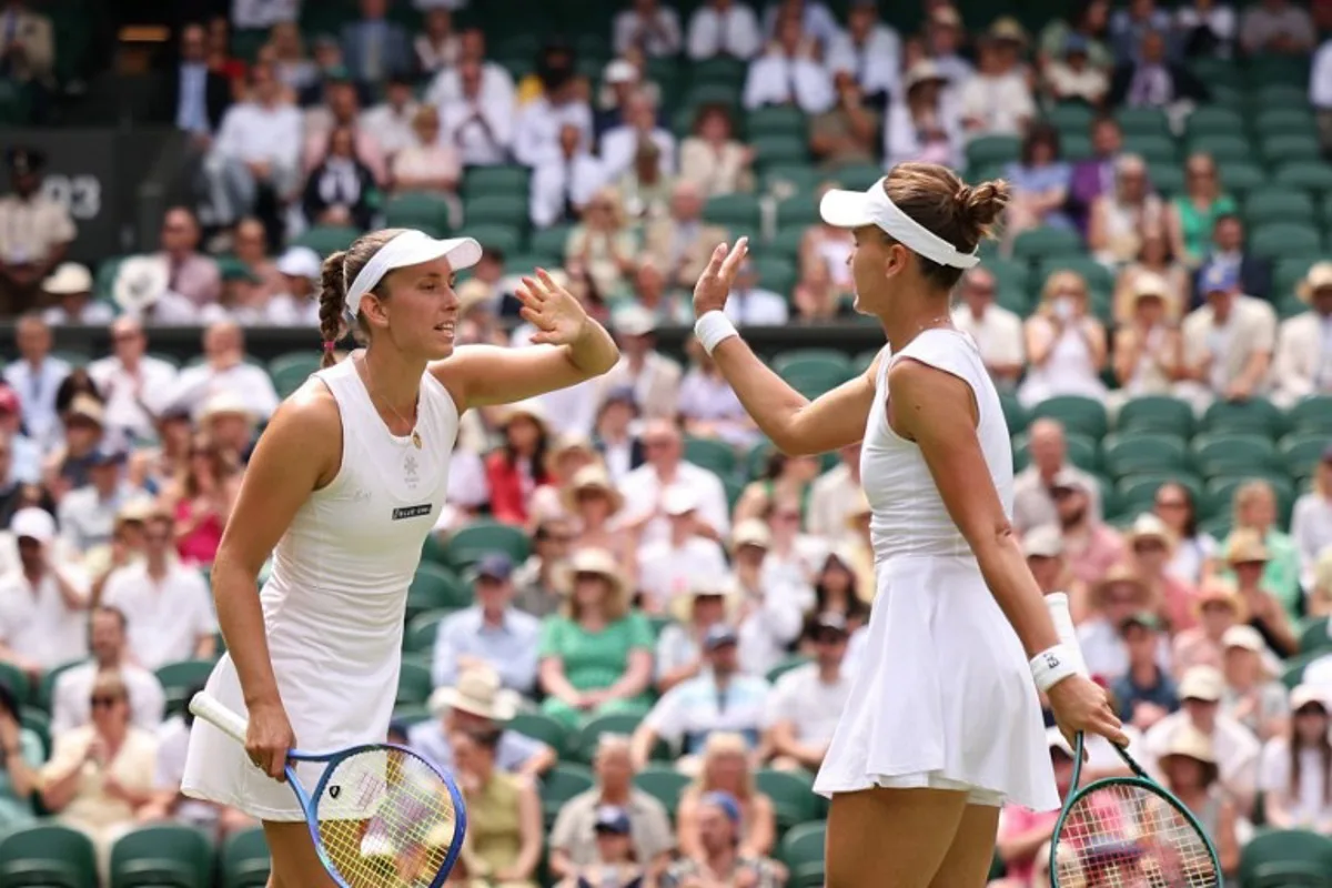 Russia's Veronika Kudermetova (R) and Belgium's Elise Mertens greet each other as they play against Taiwan's Hsieh Su-wei and Latvia's Jelena Ostapenko during their women's doubles final tennis match on the fourteenth day of the 2025 Wimbledon Championships at The All England Lawn Tennis and Croquet Club in Wimbledon, southwest London, on July 13, 2025. HENRY NICHOLLS / AFP