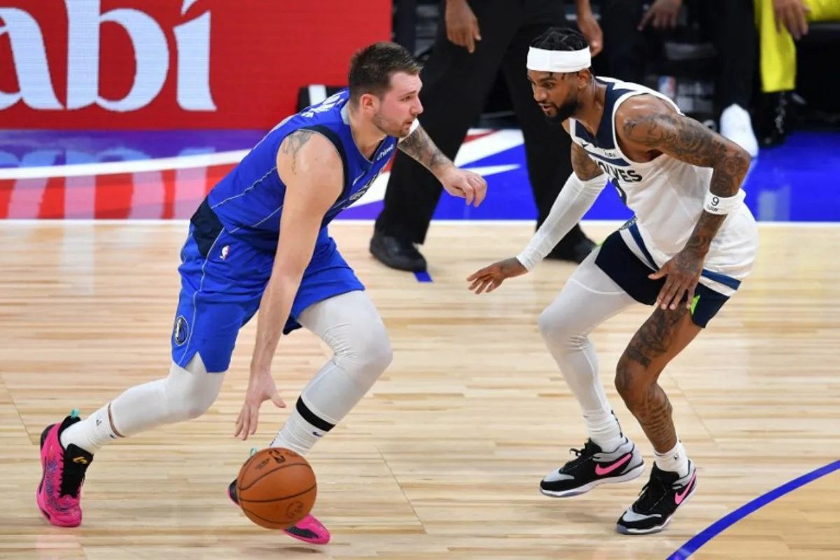 Dallas Mavericks' guard Luka Doncic #77 is marked by Minnesota Timberwolves' guard Nickeil Alexander-Walker #9 during the NBA Preseason game between the Dallas Mavericks and the Minnesota Timberwolves at the Etihad Arena in Abu Dhabi on October 7, 2023.  Ryan LIM / AFP