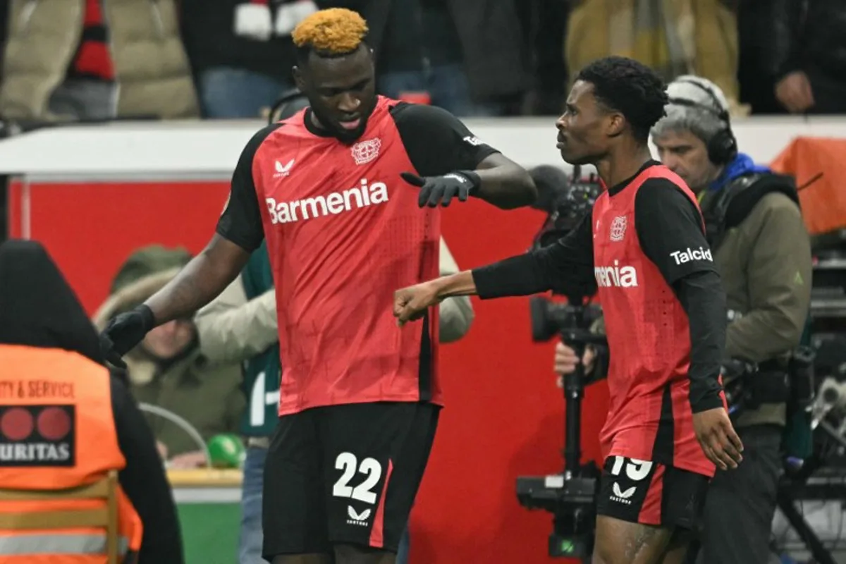 Bayer Leverkusen's Nigerian forward #22 Victor Boniface (L) celebrates scoring the 3-2 goal with his teammate Bayer Leverkusen's English midfielder #19 Nathan Tella during the German Cup (DFB Pokal) quarter-final football match  Bayer 04 Leverkusen vs FC Cologne in Leverkusen, western Germany on February 5, 2025.   INA FASSBENDER / AFP