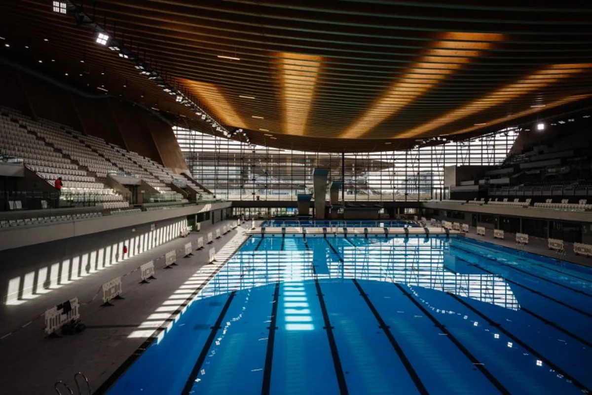 This photograph taken on March 28, 2024 shows the swimming pools and diving boards, in the Aquatics Centre built for the Paris 2024 Olympic Games to be used for artistic swimming, diving and water polo competitions in Saint Denis, near Paris. Dimitar DILKOFF / AFP