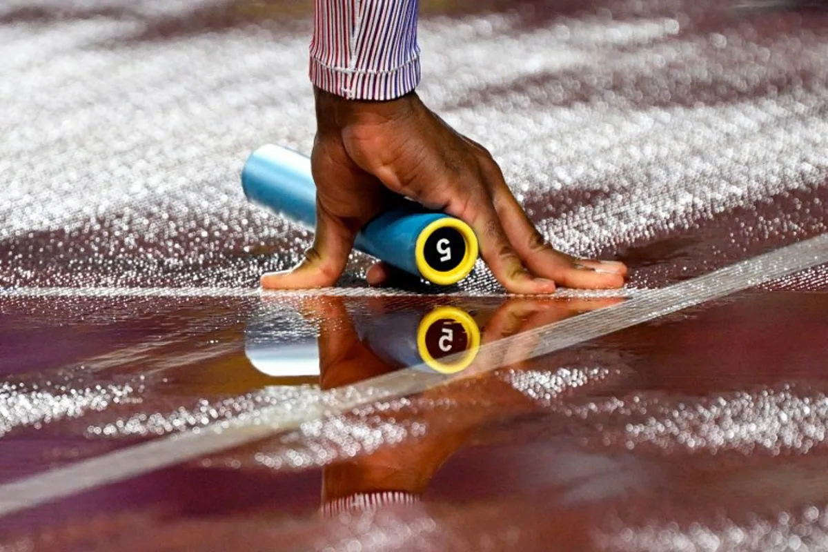 Britain's Efekemo Okoro holds a baton as he competes in the men's 4x400m relay heat during the World Athletics Relays Guangzhou 25 at Guangzhou, in southern China's Guangdong province on May 10, 2025.  WANG Zhao / AFP