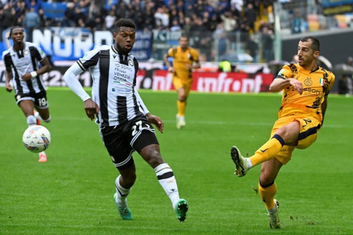 Christian Udinese's Belgian defender #27 Christian Kabasele (L) and Inter Milan's Armenian midfielder #22 Henrikh Mkhitaryan fights for the ball during the Italian Serie A football match between Udinese and Inter Milan at the Bluenergy Friuli Stadium, in Udine on September 28, 2024. ANDREA PATTARO / AFP