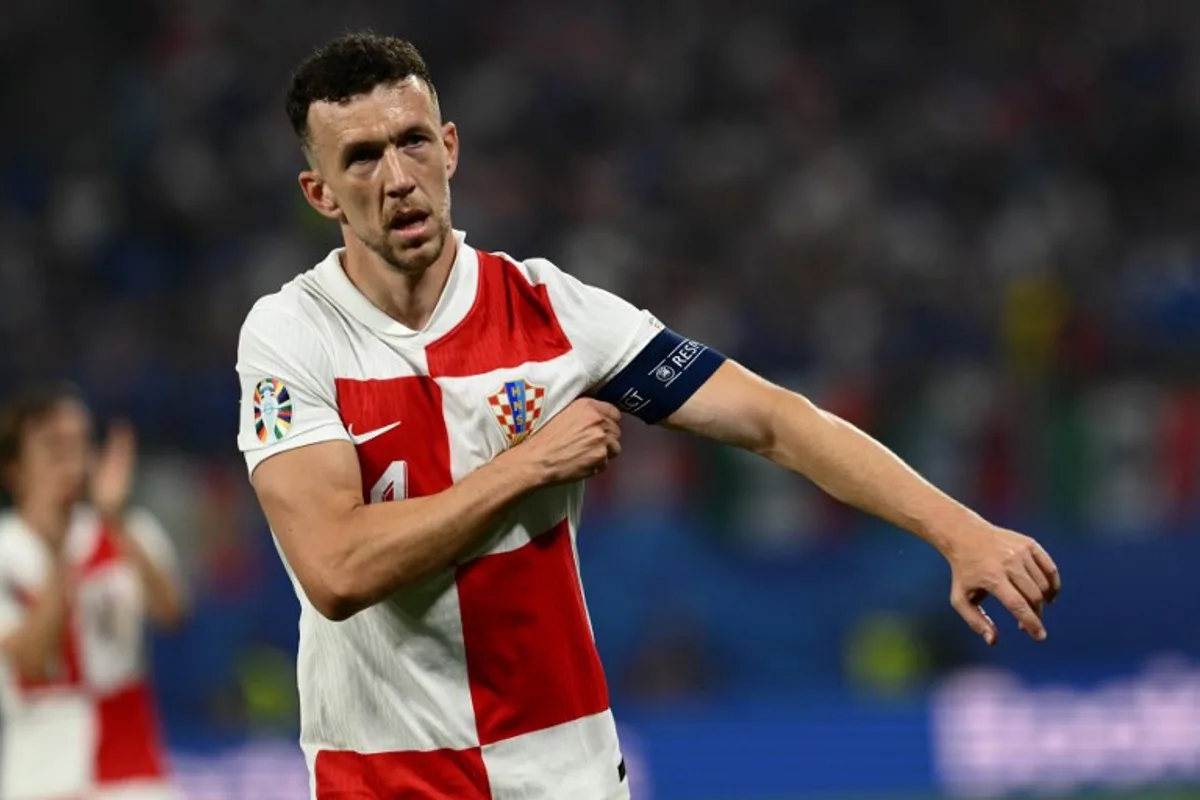 Croatia's forward #14 Ivan Perisic puts on the captain's armband during the UEFA Euro 2024 Group B football match between the Croatia and Italy at the Leipzig Stadium in Leipzig on June 24, 2024.  Christophe SIMON / AFP