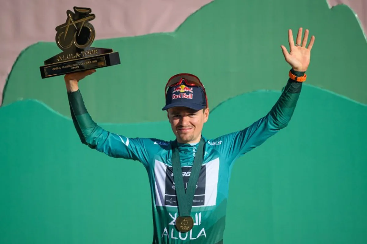 Team Q36.5 Pro Cycling Team British rider Tom Pidcock celebrates with his trophy on the podium after winning the overall AlUla Tour cycling race, after the fifth stage of the race from AlUla Camel Cup track to AlUla Camel Cup track on February 1, 2025.  Loic VENANCE / AFP