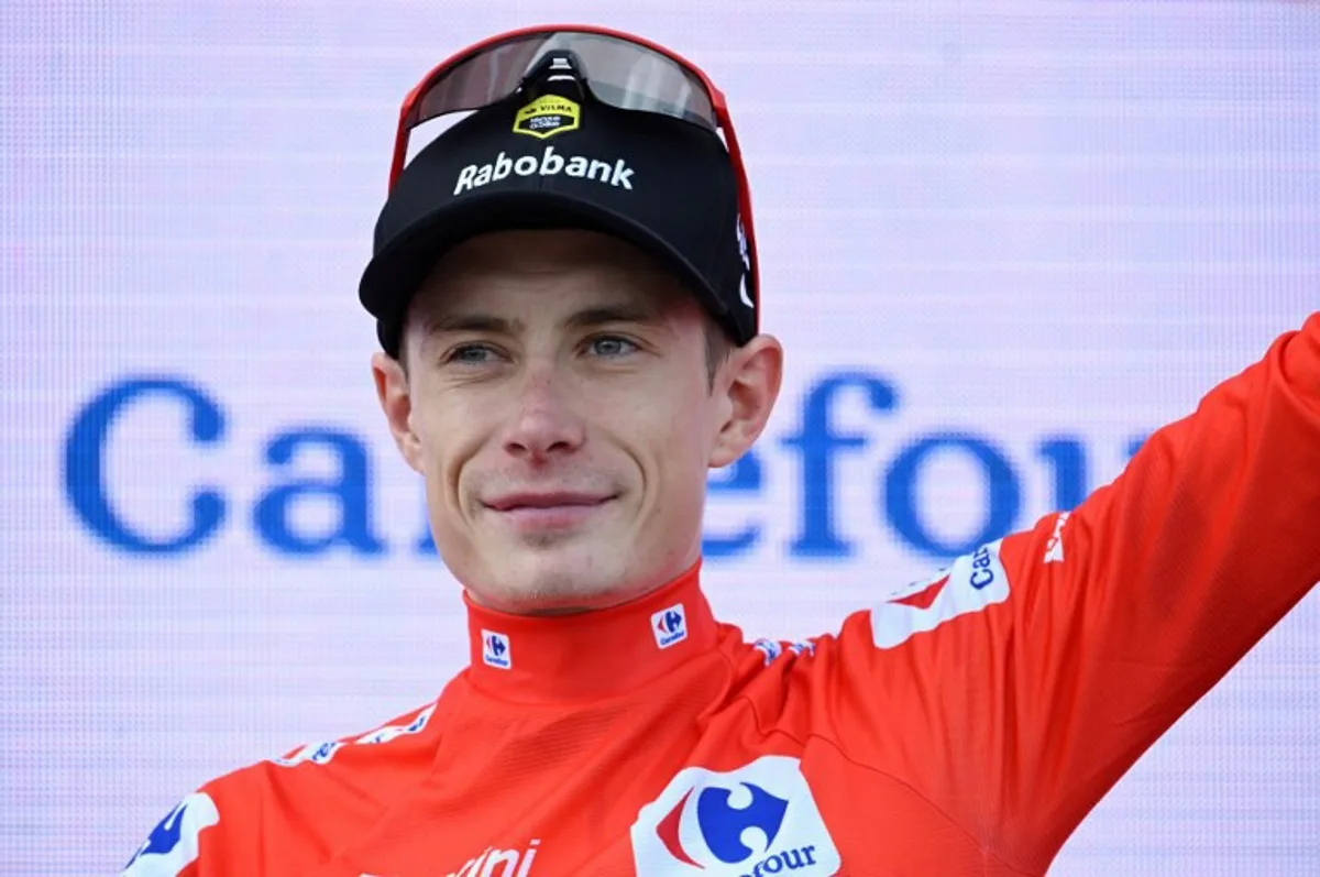 Overall leader of the Team Visma-Lease a Bike, Danish rider Jonas Vingegaard wearing the red jersey celebrates on the podium after the 15th stage of the Vuelta a Espana cycling tour, a 167 km race between A Veiga/Vegaredo and Monforte de Lemos, on September 7, 2025. Miguel RIOPA / AFP