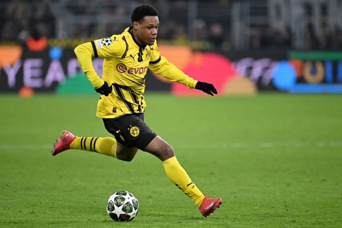 Dortmund's Belgian forward #16 Julien Duranville runs with the ball during the UEFA Champions League second-leg knockout round play-off football match BVB Borussia Dortmund vs Sporting CP at the Signal Iduna stadium in Dortmund, western Germany, on February 19, 2025.  UWE KRAFT / AFP