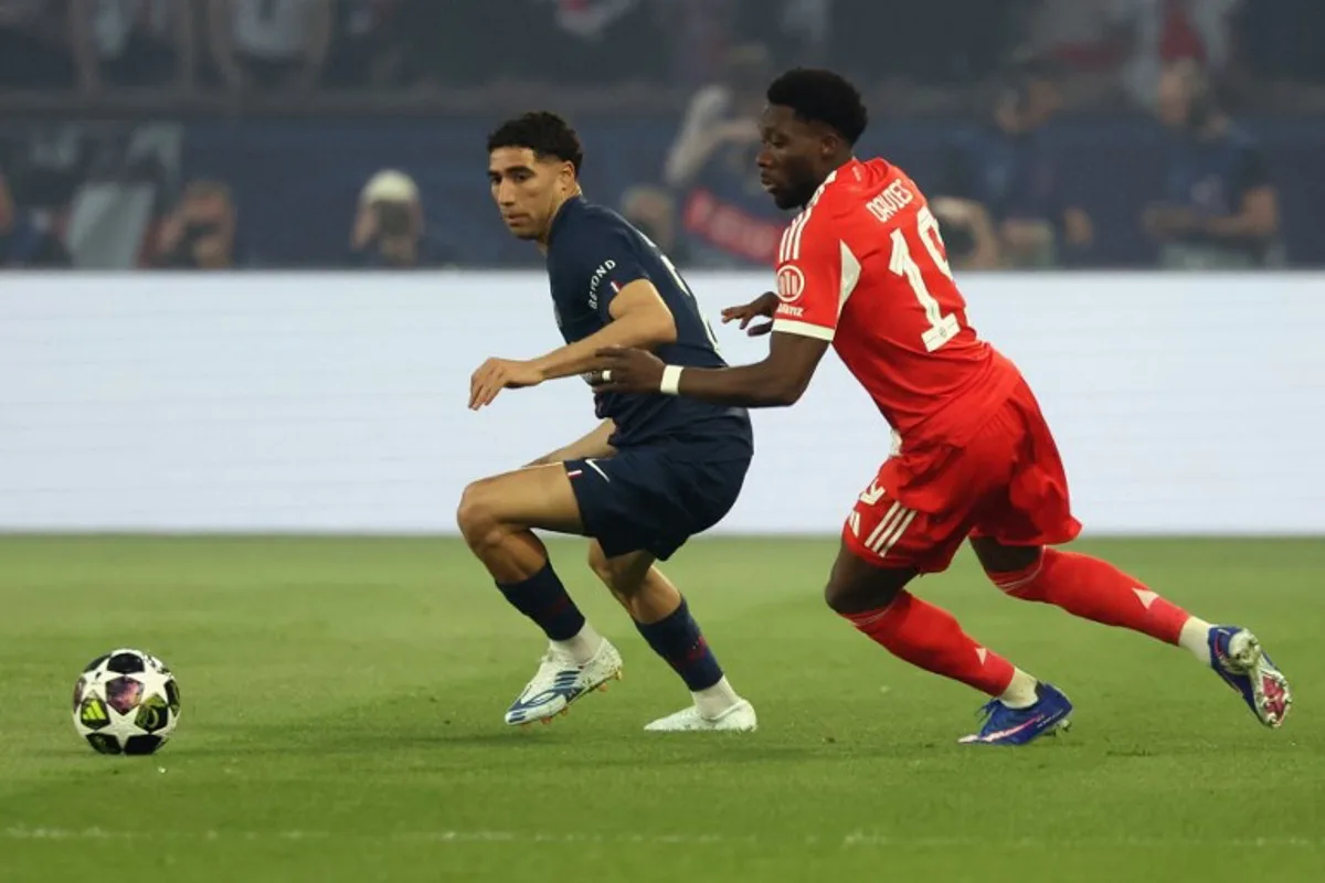 Morocco's defender #02 Achraf Hakimi (L) fights for the ball with Bayern Munich's Canadian defender #19 Alphonso Davies during the UEFA Champions League semi-final first leg football match between Paris Saint-Germain (PSG) and Bayern Munich at the Parc des Princes in Paris on April 28, 2026.  ALAIN JOCARD / AFP