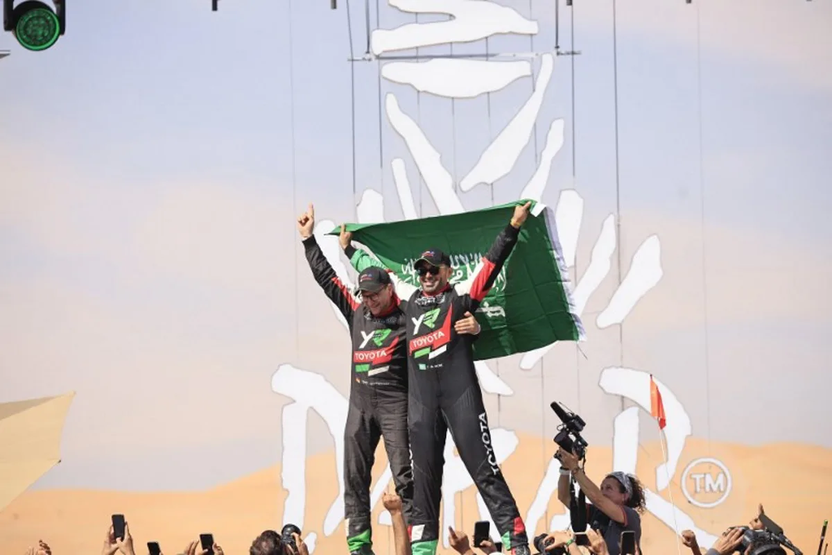 Saudi driver Yazeed Al Rajhi (R) and co-driver Edouard Boulanger (L) celebrate after winning the Dakar Rally 2025 in the car category at the end of the 12th and last stage in Shubaytah, on January 17, 2025.  Valery HACHE / AFP