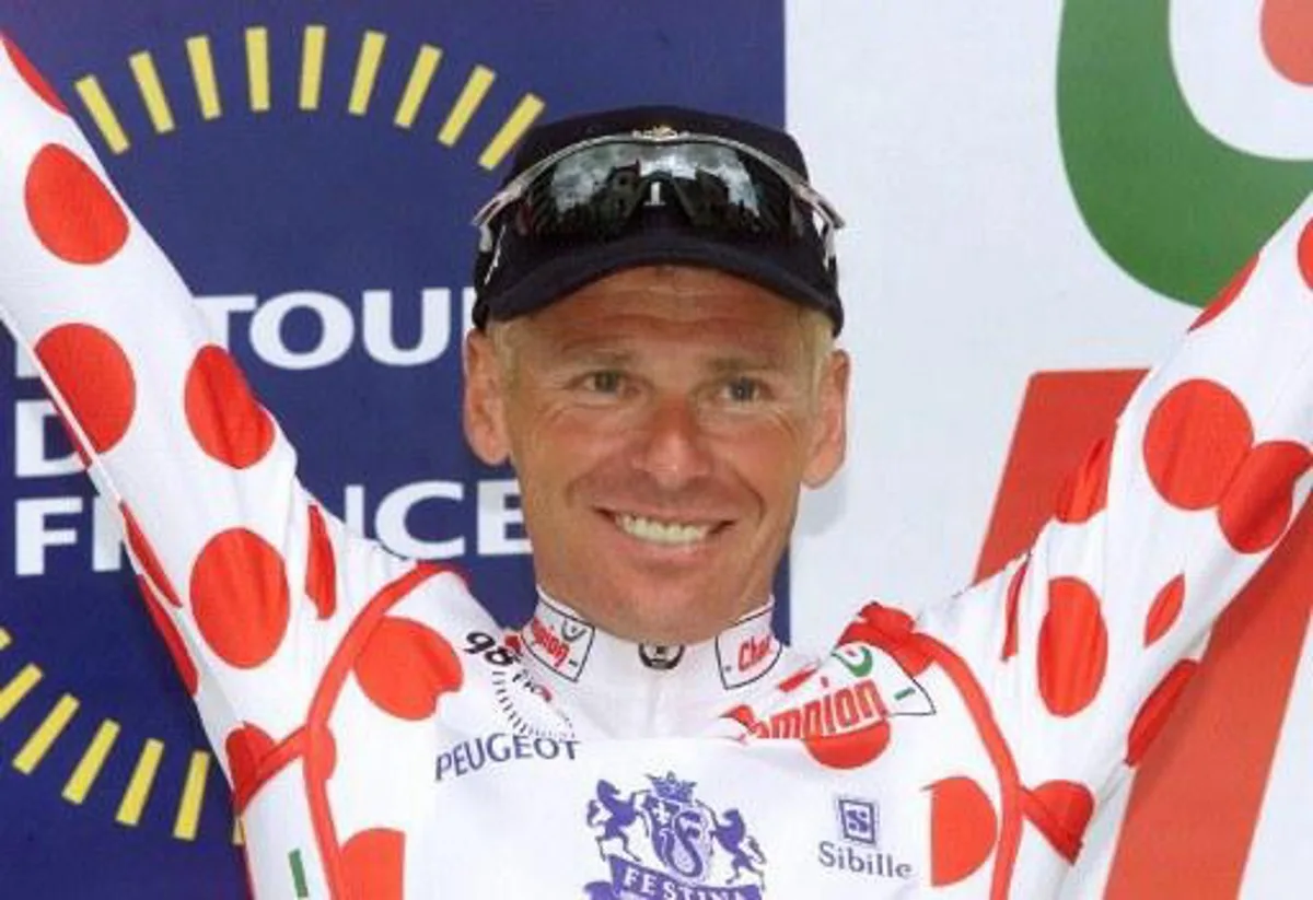 Festina team's cyclist Frenchman Pascal Herve wearing the polka-dot jersey jubilates on the podium of the fourth stage of the 85th Tour de France in Cholet, West of France, 15 July. (ELECTRONIC IMAGE)    AFP PHOTO