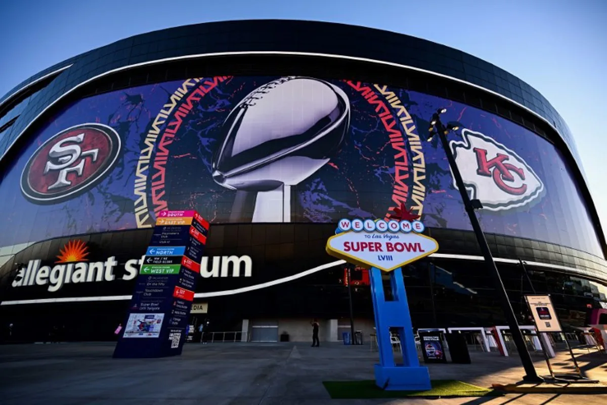 A Welcome To Las Vegas Super Bowl LVIII sign stands at sunrise outside of Allegiant Stadium wrapped with the logos of the Kansas City Chiefs and San Francisco 49ers with the NFL Lombardi Trophy ahead of Super Bowl LVIII in Las Vegas, Nevada, on February 11, 2024.  Patrick T. Fallon / AFP