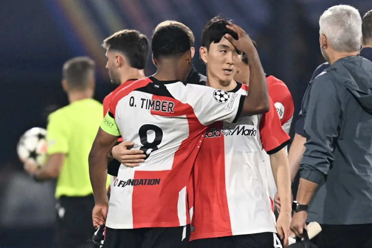 Feyenoord's Dutch midfielder #08 Quinten Timber (L) reacts with Feyenoord's South Korean midfielder #04 In-Beom Hwang (R) after the UEFA Champions League 1st round day 1 football match between Feyenoord  and Bayer Leverkusen at The De Kuip Stadium, in Rotterdam on September 19, 2024.  JOHN THYS / AFP