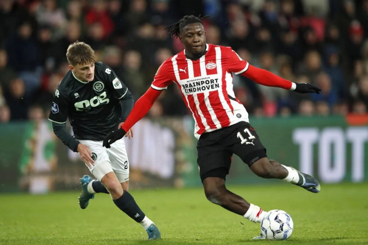 PSV Eindhoven's Belgian forward Johan Bakayoko (R) fights for the ball with FC Groningen's  Dutch defender Wouter Prins during the Dutch Eredivisie football match between PSV Eindhoven and FC Groningen at Phillips Stadium in Eindhoven on November 23, 2024.   Bart Stoutjesdijk / ANP / AFP