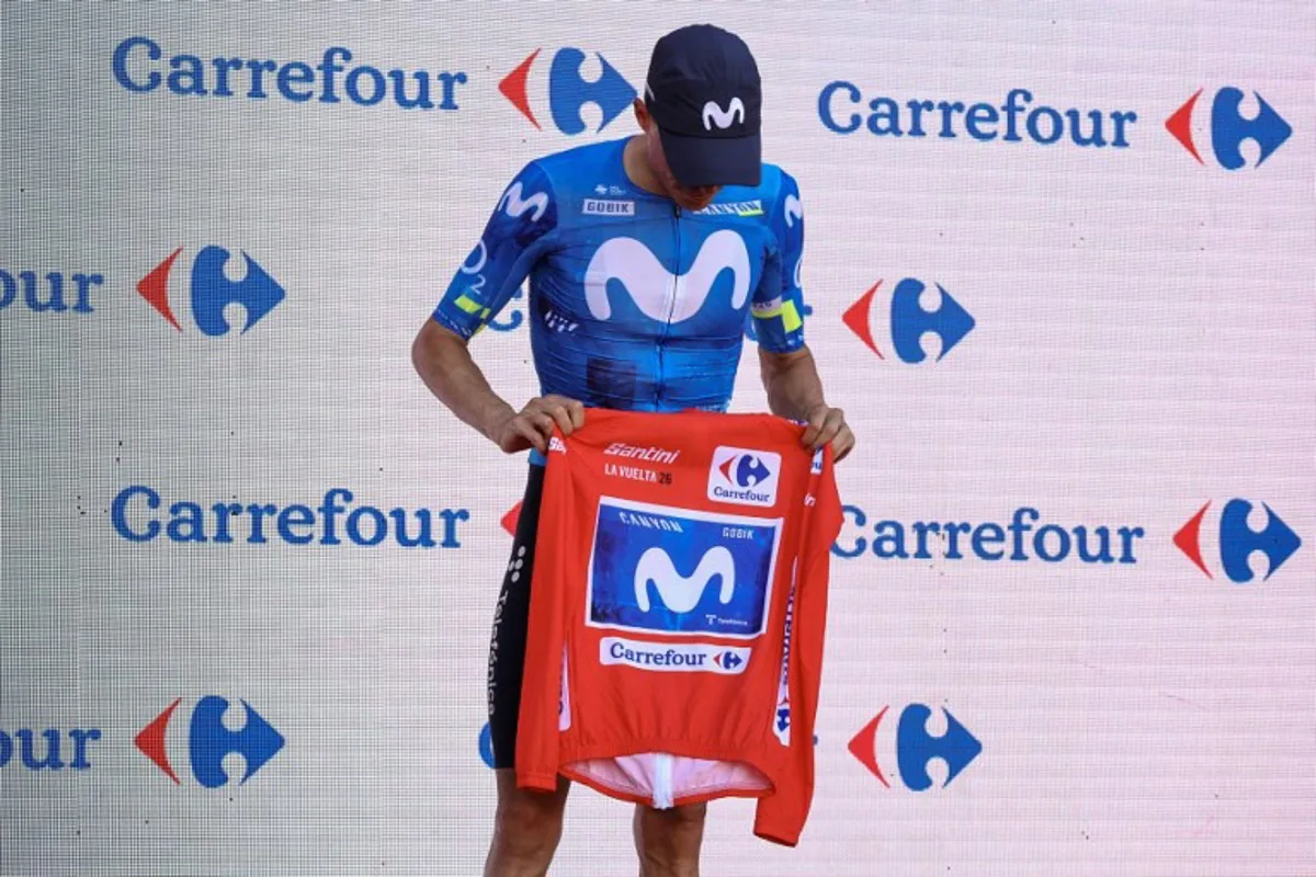 New overall race leader Team Movistar's Spanish rider Enric Mas holds the race leader's red jerse without wearing it on the podium after the eighth stage of the Vuelta a Espana 2026, a 171 km race between Pucol and Xeraco on August 29, 2026. Previous race leader Tadej Pogacar pulled out of the Vuelta a Espana on Saturday after a heavy fall 31km from the finish of a flat stage eight left him with shoulder and face injuries. Pogacar of Team UAE has won five Tour de France titles and a Giro d'Italia and was targetig his first overall victory on the Spanish 21-day race. Josep LAGO / AFP