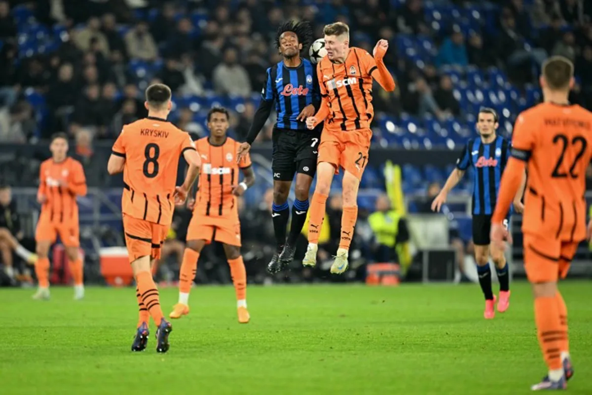 Shakhtar Donetsk's Ukrainian midfielder #21 Artem Bondarenko (3R) and Atalanta's Colombian midfielder #07 Juan Cuadrado (3L) jump to head the ball during the UEFA Champions League football match between FC Shakhtar Donetsk and Atalanta Bergamo in Gelsenkirchen, western Germany on October 2, 2024.  INA FASSBENDER / AFP