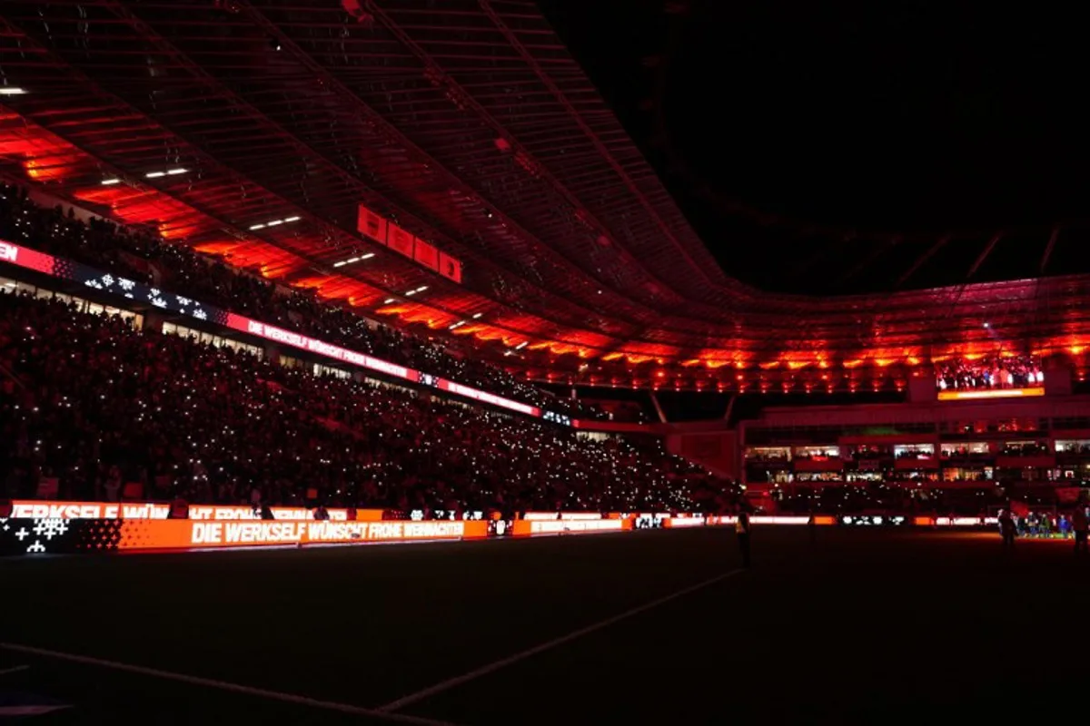 Leverkusen's fans hold up lights after the German first division Bundesliga football match between Bayer Leverkusen and SC Freiburg in Leverkusen on December 21, 2024.  Pau BARRENA / AFP