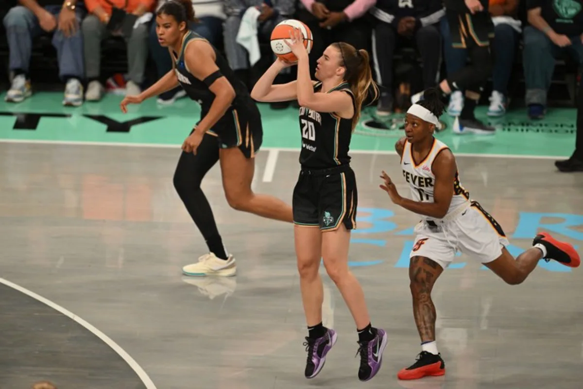 New York Liberty #20 Sabrina Ionescu (C) shoots the ball during a WNBA game between the Indiana Fever and New York Liberty, at the Barclays Center in Brooklyn on May 18, 2024, in New York City.  ANGELA WEISS / AFP