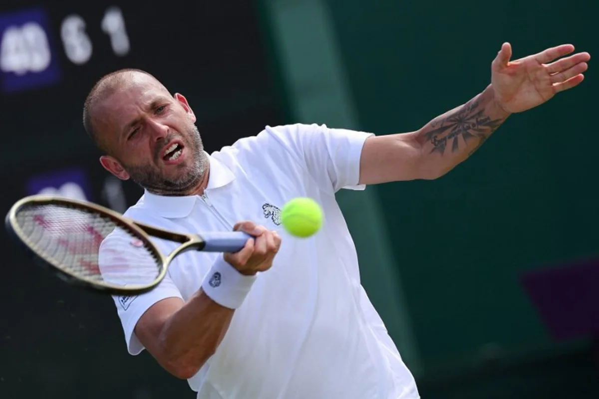 Britain's Daniel Evans plays a forehand return to Britain's Jay Clarke during their men's singles first round tennis match on the second day of the 2025 Wimbledon Championships at The All England Lawn Tennis and Croquet Club in Wimbledon, southwest London, on July 1, 2025. Adrian Dennis / AFP