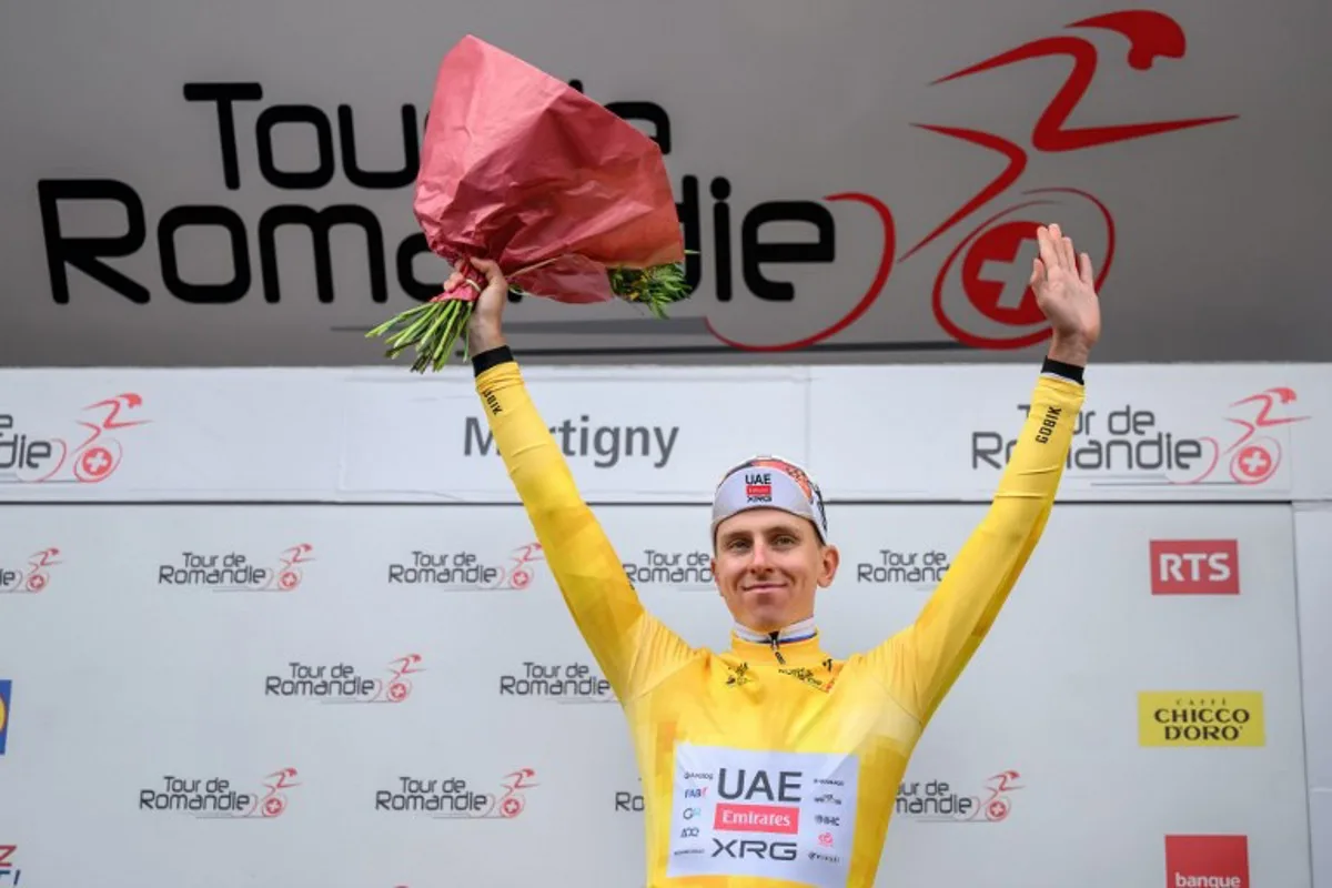 UAE Team Emirates-XRG's Slovenian rider Tadej Pogacar wearing the overall leader's yellow jersey celebrates on the podium of the first stage of the Tour of Romandie UCI cycling World tour, a 171.2 km loop from Martigny-Ville to Martigny-Ville, in Martigny, on April 29, 2026.  Fabrice COFFRINI / AFP
