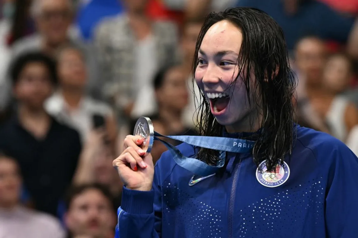 Silver medallist US' Torri Huske celebrates on the podium after the women's 100m freestyle swimming event during the Paris 2024 Olympic Games at the Paris La Defense Arena in Nanterre, west of Paris, on July 31, 2024. Jonathan NACKSTRAND / AFP