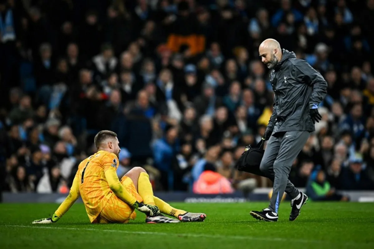 Tottenham Hotspur's Italian goalkeeper #01 Guglielmo Vicario receives medical attention during the English Premier League football match between Manchester City and Tottenham Hotspur at the Etihad Stadium in Manchester, north west England, on November 23, 2024.  Paul ELLIS / AFP