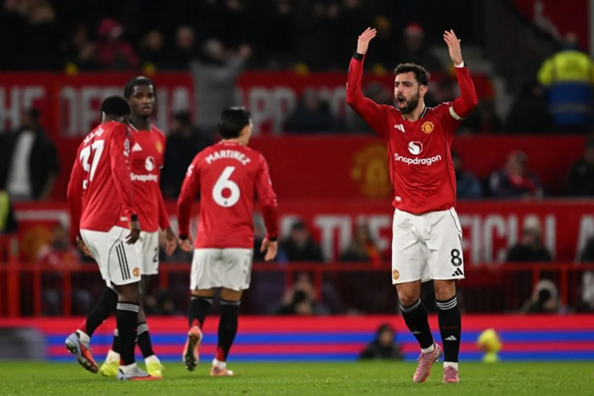 Manchester United's Portuguese midfielder #08 Bruno Fernandes gestures to the crowd as he celebrates scoring their third goal to equalise 3-3 during the English Premier League football match between Manchester United and Bournemouth at Old Trafford in Manchester, north west England, on December 15, 2025.  PETER POWELL / AFP