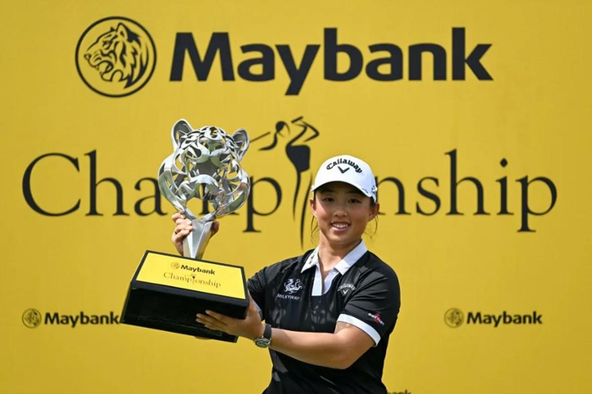 China's Yin Ruoning celebrates with the trophy after winning the LPGA Maybank Championship golf tournament at the Kuala Lumpur Golf and Country Club in Kuala Lumpur on October 27, 2024.  Mohd RASFAN / AFP