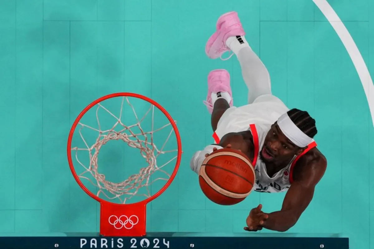 An overview shows Canada's #02 Shai Gilgeous-Alexander going for a rebound in the men's preliminary round group A basketball match between Canada and Australia during the Paris 2024 Olympic Games at the Pierre-Mauroy stadium in Villeneuve-d'Ascq, northern France, on July 30, 2024.  POOL / AFP