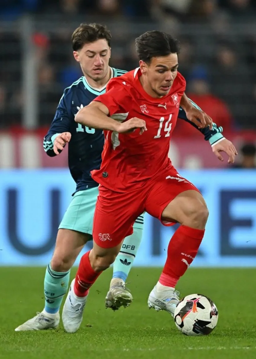 Germany's midfielder Angelo Stiller fights for the ball with Switzerland's midfielder #14 Ardon Jashari during the international friendly football match between Switzerland and Germany at St. Jakob-Park in Basel, Switzerland on March 27, 2026.  Fabrice COFFRINI / AFP