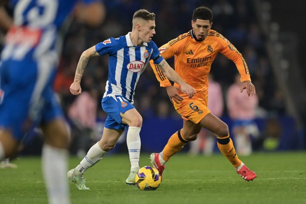 Espanyol's Spanish midfielder #10 Pol Lozano (L) is challenged by Real Madrid's English midfielder #05 Jude Bellingham during the Spanish league football match between RCD Espanyol and Real Madrid CF at the RCDE Stadium in Cornella de Llobregat on February 1, 2025.  MANAURE QUINTERO / AFP