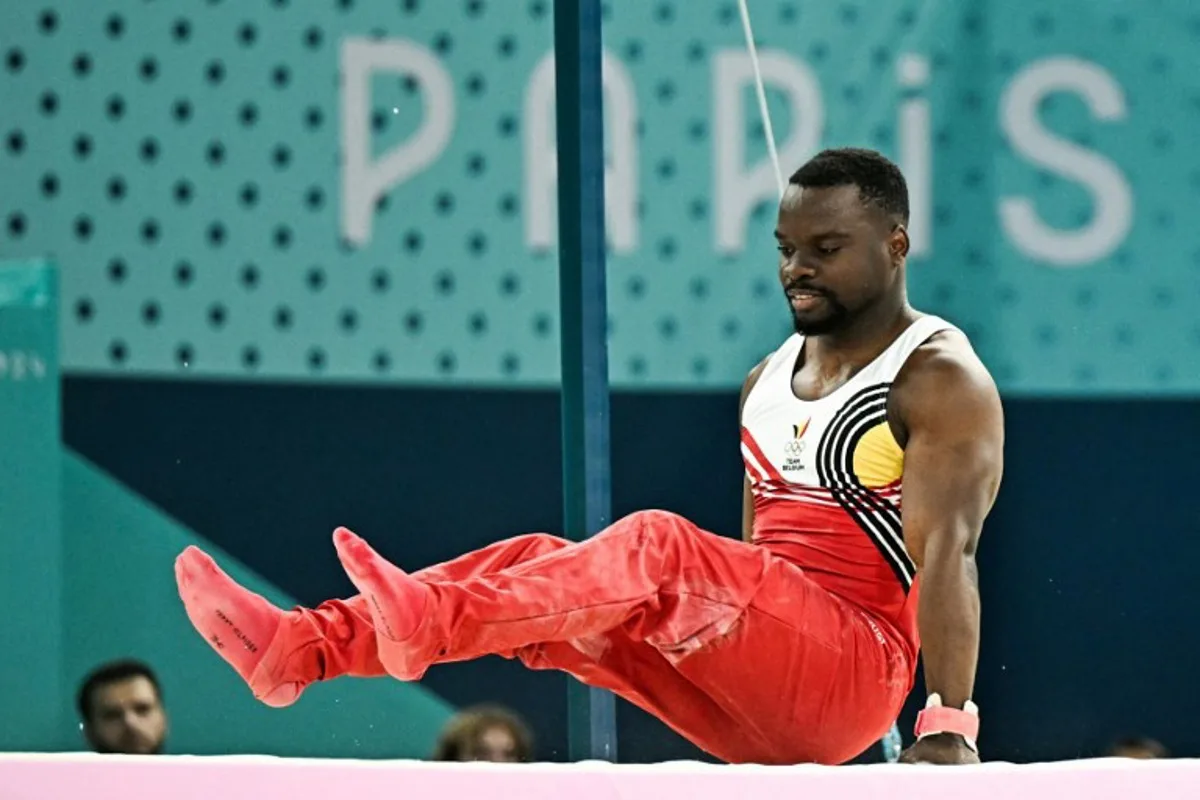 Belgium's Noah Kuavita falls as he competes in the horizontal bar event of the artistic gymnastics men's qualification during the Paris 2024 Olympic Games at the Bercy Arena in Paris, on July 27, 2024.  Gabriel BOUYS / AFP