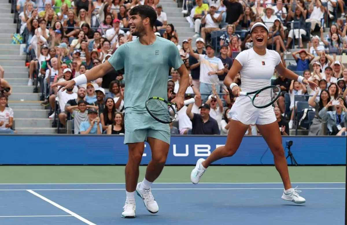 Britain's Emma Raducanu and Carlos Alcaraz of Spain celebrate a point during their first round mixed doubles match against Jessica Pegula of the US and Jack Draper of Britain at the US Open tennis tournament at the USTA Billie Jean King National Tennis Center in New York City on August 19, 2025.  TIMOTHY A. CLARY / AFP