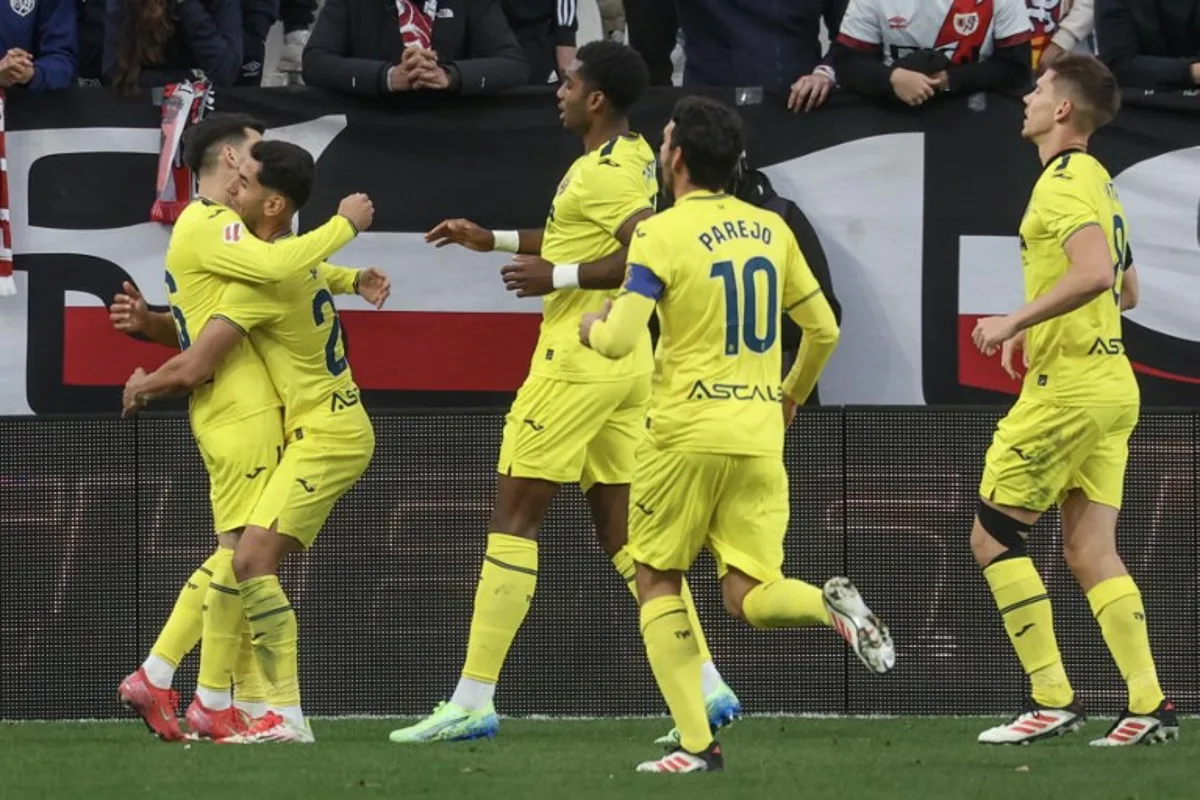 Villarreal's Spanish forward #22 Ayoze Perez Gutierrez (L) celebrates with teammates after scoring their first goal during the Spanish league football match between Rayo Vallecano de Madrid and Villarreal CF at Vallecas Stadium in Madrid on February 22, 2025.  Pierre-Philippe MARCOU / AFP