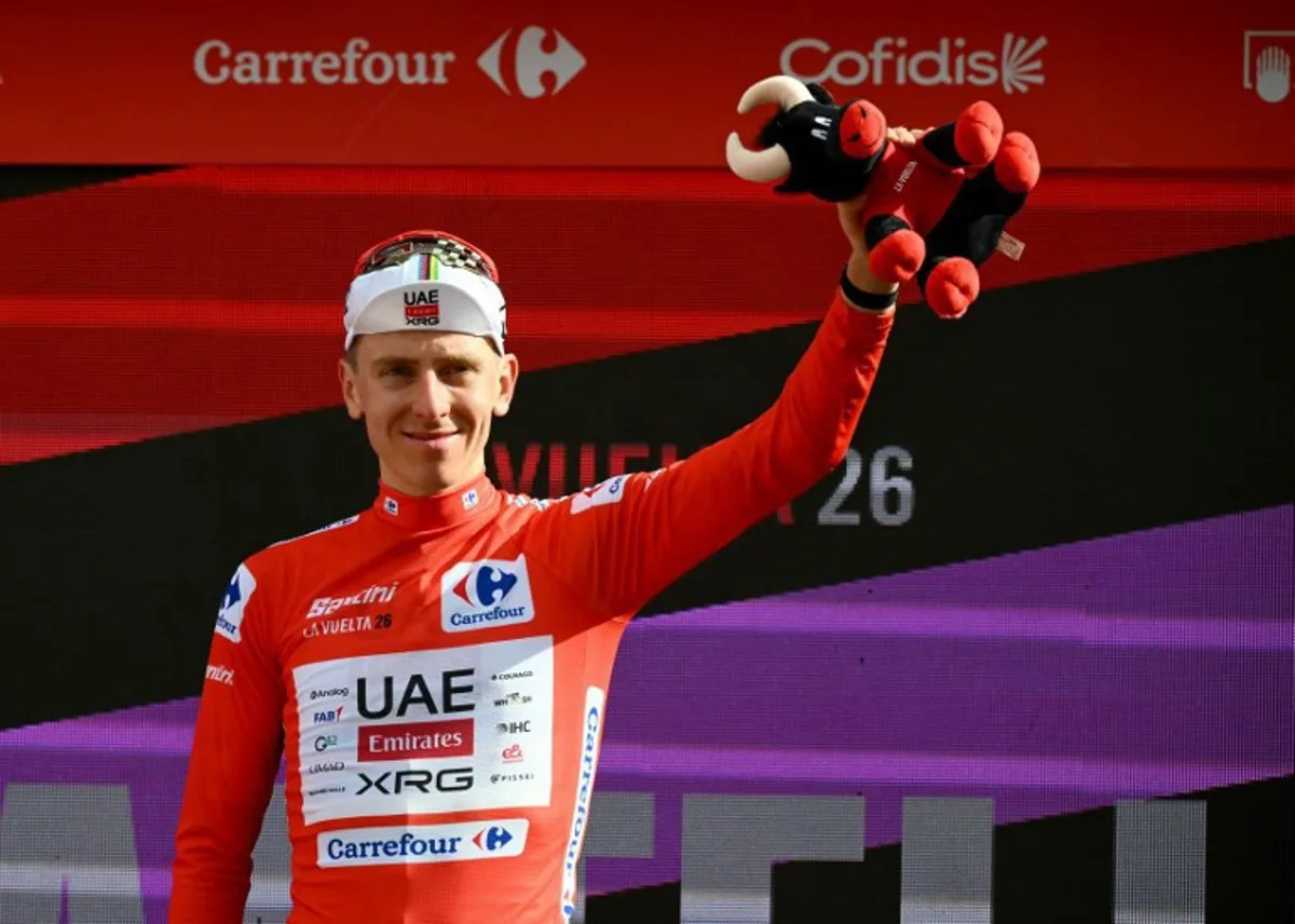 Team UAE's Slovenian rider Tadej Pogacar wearing the overall leader red jersey celebrates on the podium the sixth stage of the Vuelta a Espana 2026, a 177,4 km race between Alcossebre and Castellon de la Plana on August 27, 2026. JOSE JORDAN / AFP