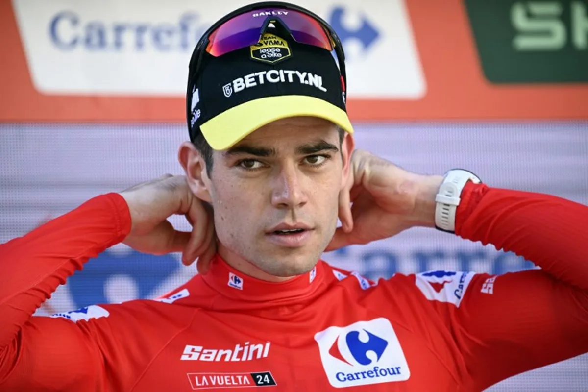 The overall ranking leader, Team Visma's Wout van Aert, puts the red jersey on as he celebrates on the podium after winning the stage 3 of La Vuelta a Espana cycling tour, a 191.2 km race between Lousa and Castelo Branco, on August 19, 2024.   MIGUEL RIOPA / AFP