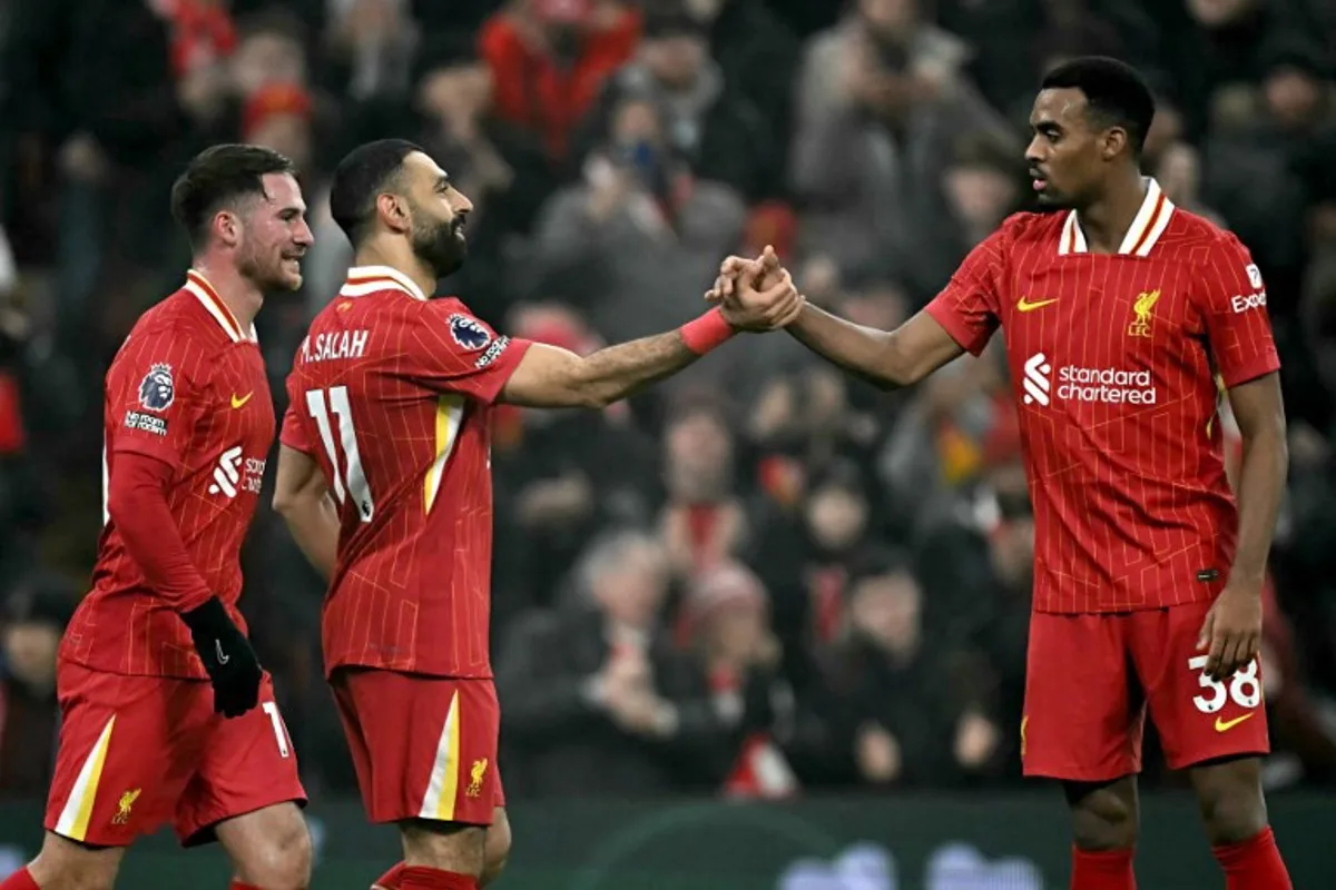 Liverpool's Egyptian striker #11 Mohamed Salah celebrates scoring the team's third goal with Liverpool's Dutch midfielder #38 Ryan Gravenberch (R) during the English Premier League football match between Liverpool and Leicester City at Anfield in Liverpool, north west England on December 26, 2024.  Paul ELLIS / AFP