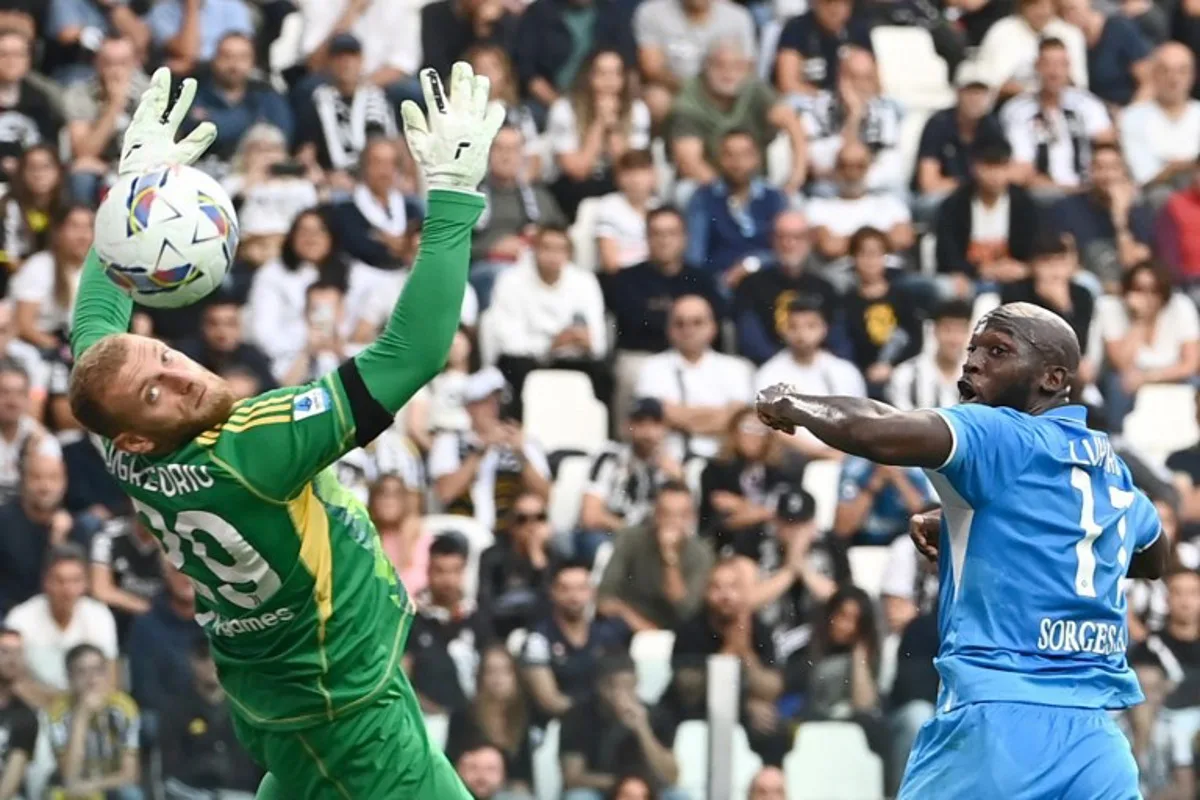 Napoli's Belgian forward #11 Romelu Lukaku (R) reacts next to Juventus' Italian goalkeeper #29 Michele Di Gregorio during an Italian Serie A football match between Juventus and Napoli at the Allianz Stadium in Turin, on September 21, 2024.  Isabella BONOTTO / AFP