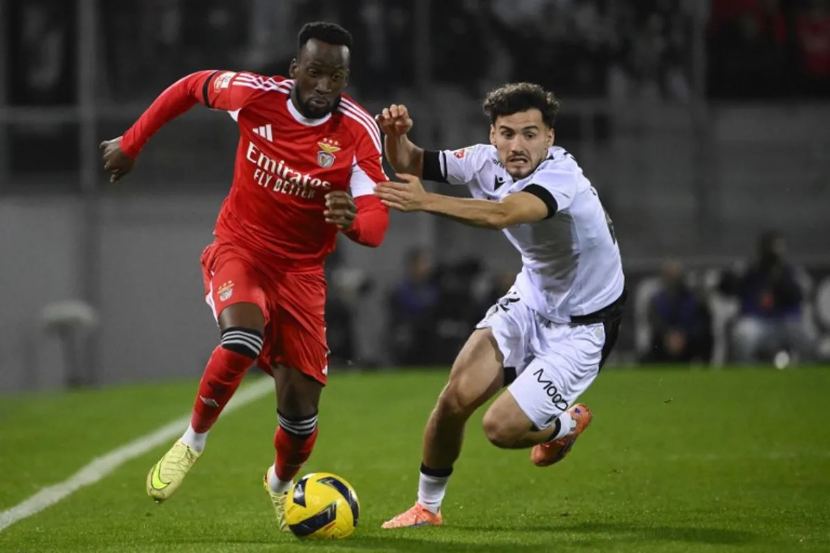 SL Benfica's Belgian forward #11 Dodi Lukebakio and Vitoria Guimaraes's Spanish forward #22 Fabio Blanco during the Portuguese League football match between Vitoria Guimaraes SC and SL Benfica at Dom Afonso Henriques stadium in Guimaraes on November 1, 2025. Miguel RIOPA / AFP