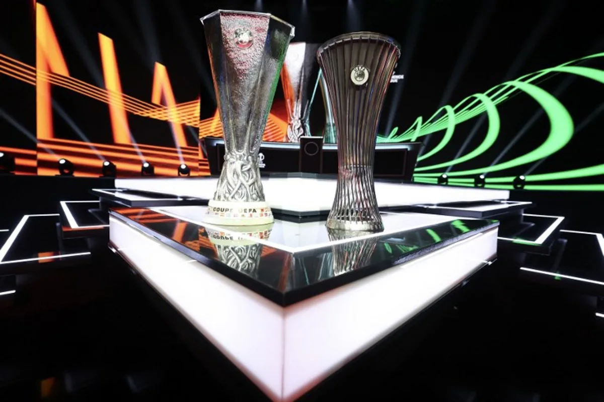 This photograph taken on August 28, 2026 shows the Europa League trophy (L) and Conference League trophy (R) during the draw ceremony for the league phase of the 2026-2027 UEFA Europa and Conference League football tournaments at the Grimaldi Forum in the Principality of Monaco.  Valery HACHE / AFP