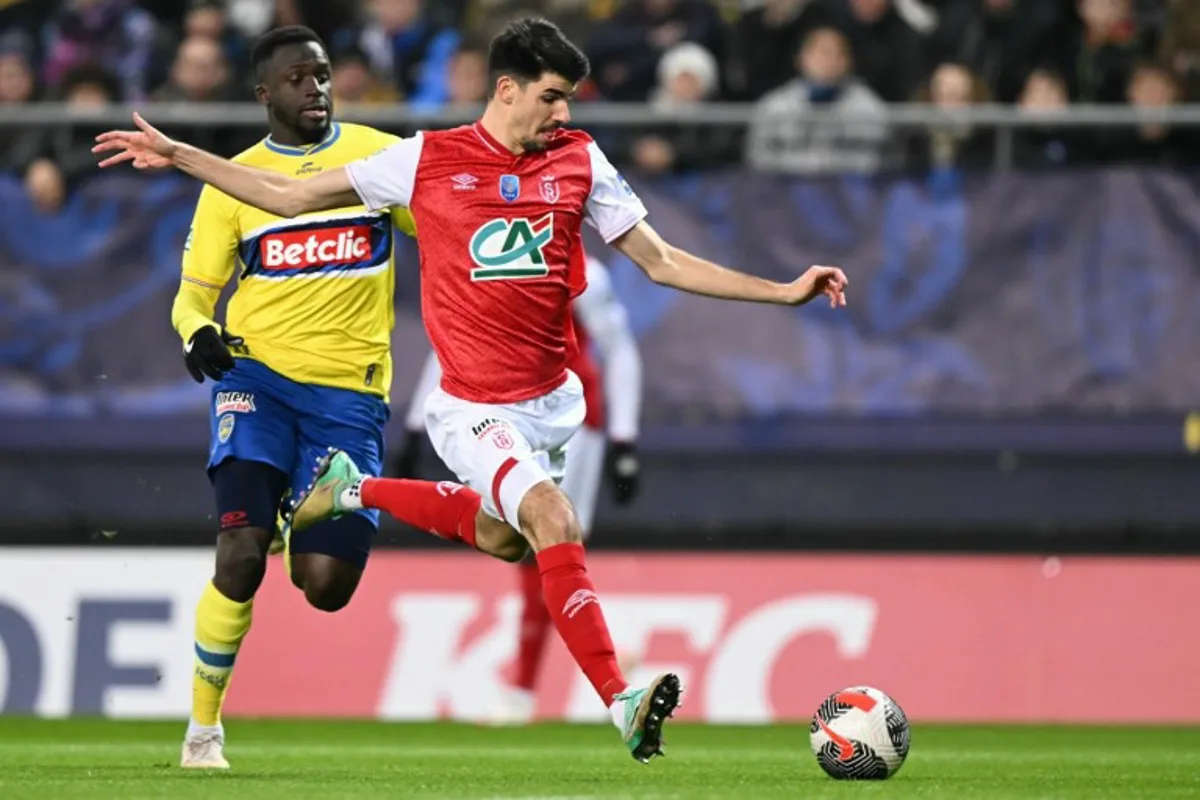 Reims' Belgian defender #03 Thibault De Smet (C) fights for the ball with Sochaux French defender #03 Julien Dacosta (L) during the French Cup round of 32 football match between FC Sochaux-Montbeliard and Stade de Reims at the Bonal stadium in Montbeliard on January 21, 2024.  SEBASTIEN BOZON / AFP