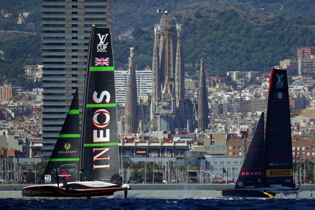 Italy's Luna Rossa Prada Pirelli (R) and Britain's Ineos Britannia compete on day seven of the 37th America's Cup finals, off the coast of Barcelona on October 4, 2024, as Sagrada Familia basilica is seen in the background.  Manaure Quintero / AFP