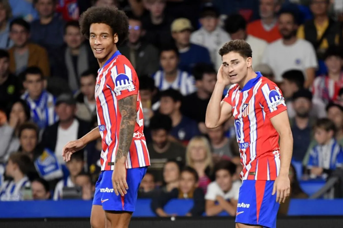 Atletico Madrid's Argentine forward #19 Julian Alvarez (R) celebrates scoring the opening goal next to Atletico Madrid's Belgian midfielder #20 Axel Witsel during the Spanish league football match between Real Sociedad and Club Atletico de Madrid at the Anoeta stadium in San Sebastian on October 6, 2024.  Ander Gillenea / AFP