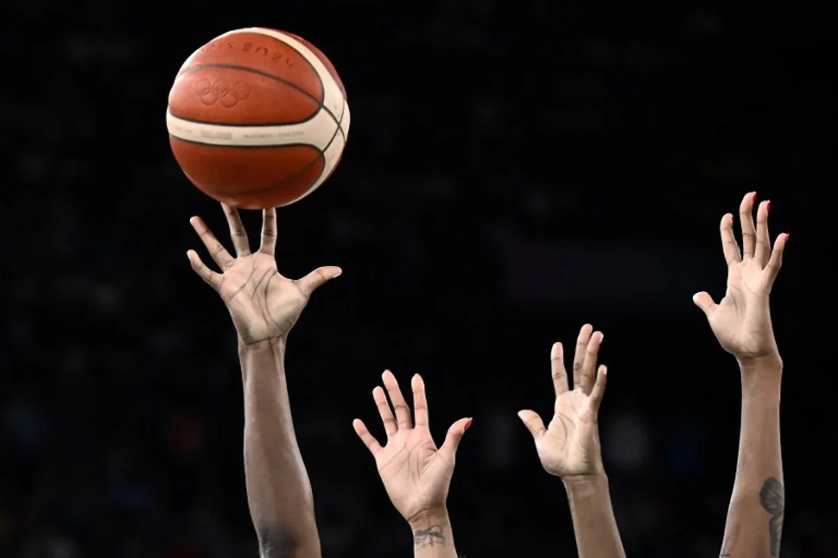 USA's #13 Jackie Young (L) and France's #11 Valeriane Ayayi go for a rebound in the women's Gold Medal basketball match between France and the USA during the Paris 2024 Olympic Games at the Bercy  Arena in Paris on August 11, 2024.  Aris MESSINIS / AFP