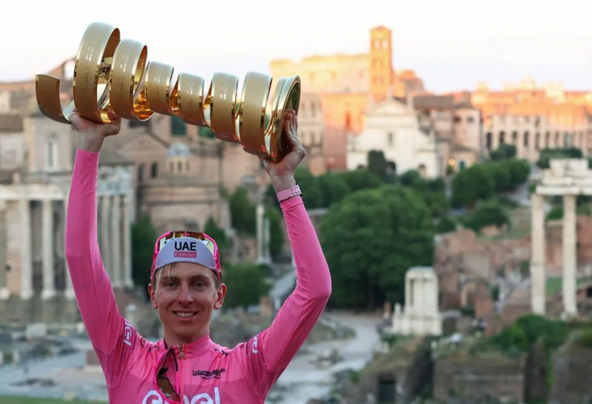 Team UAE's Slovenian rider Tadej Pogacar wearing the overall leader's pink jersey poses for photographs with the "Trofeo Senza Fine" (Endless or Infinity Trophy) in front of the Foro Romano (Roman Forum) after the 21st and last stage of the 107th Giro d'Italia cycling race, 125km from Rome to Rome on May 26, 2024.   Luca Bettini / AFP