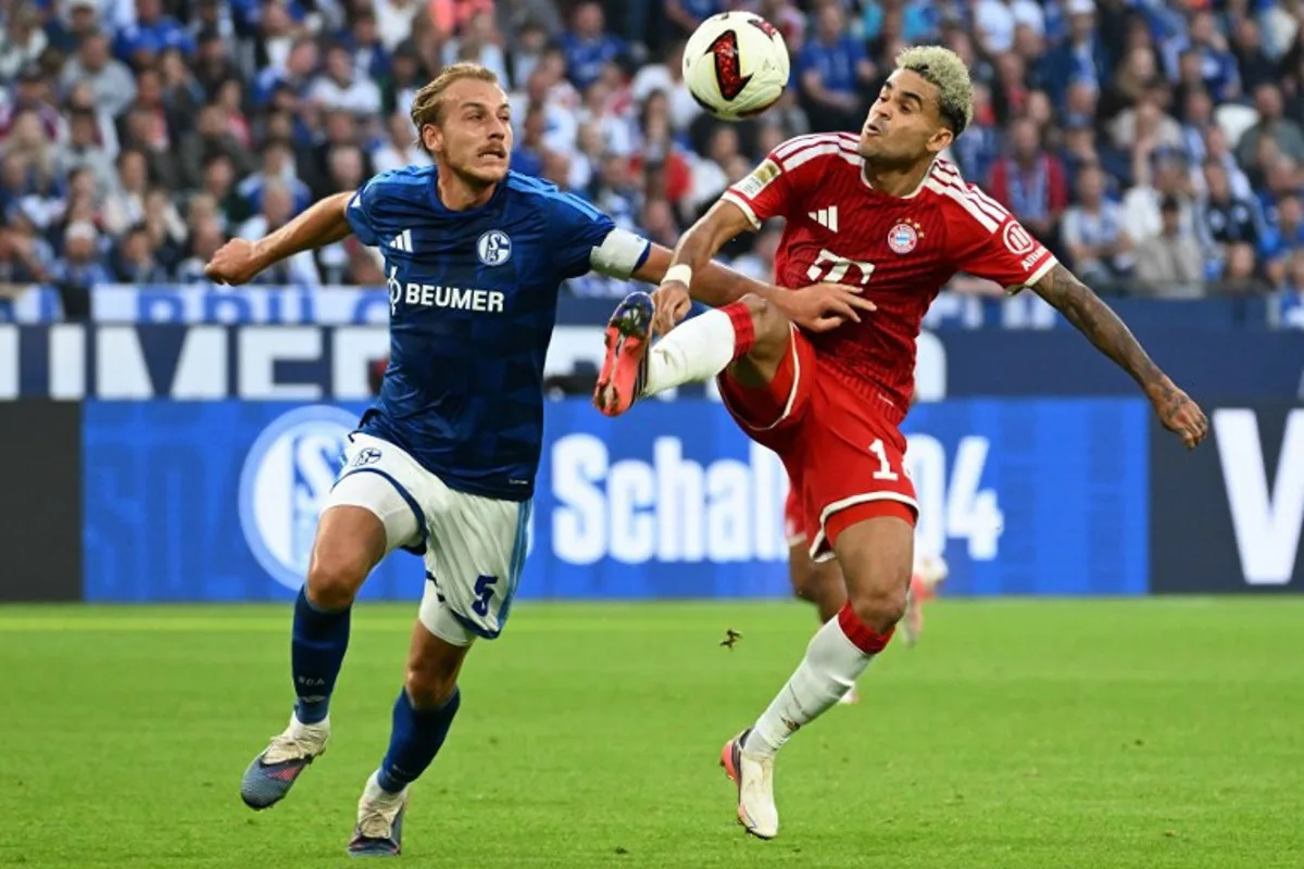 Schalke's German defender #05 Timo Becker (L) and Bayern Munich's Colombian forward #14 Luis Diaz vie for the ball during the German first division Bundesliga football match between Schalke 04 and FC Bayern Munich in Gelsenkirchen, western Germany on September 5, 2026. UWE KRAFT / AFP